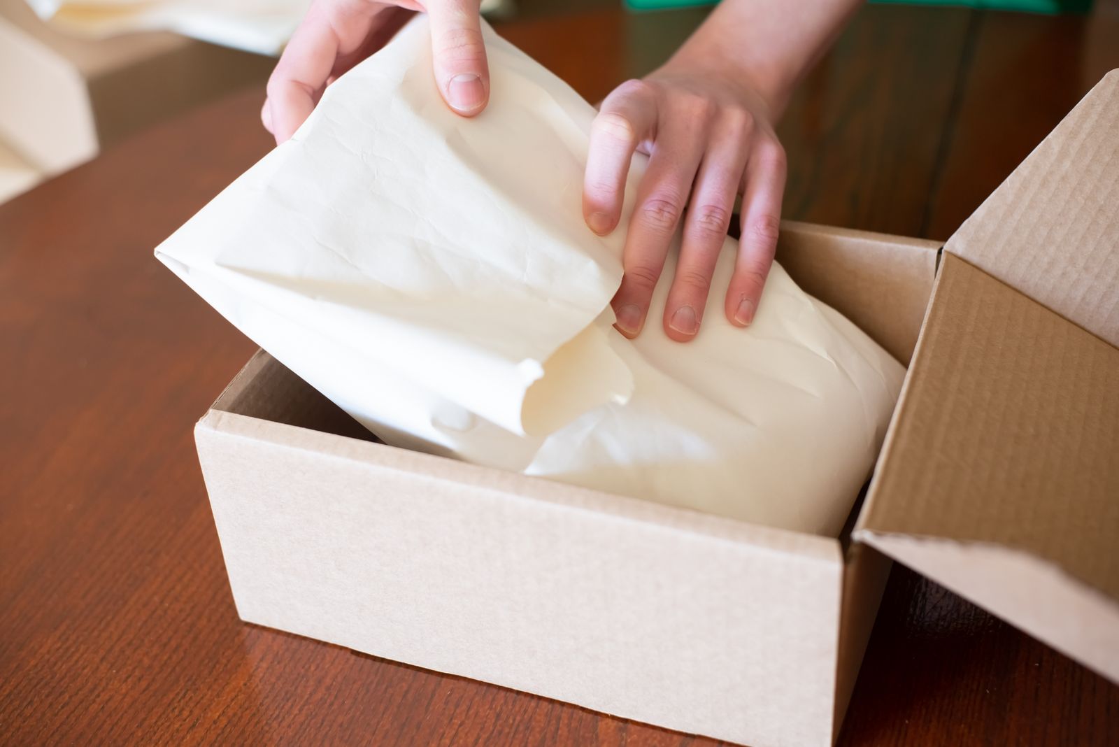 A shipping box being packed with protective material